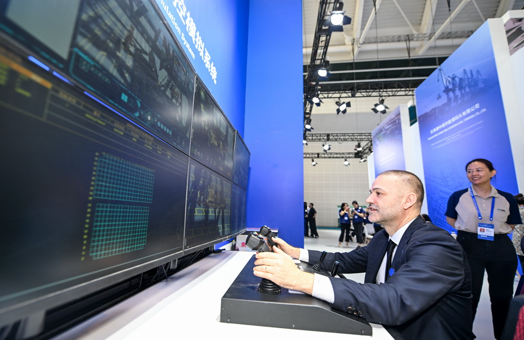 6月12日，與會者在博覽會天津港展臺體驗碼頭遠程操控模擬系統。新華社記者 趙子碩 攝