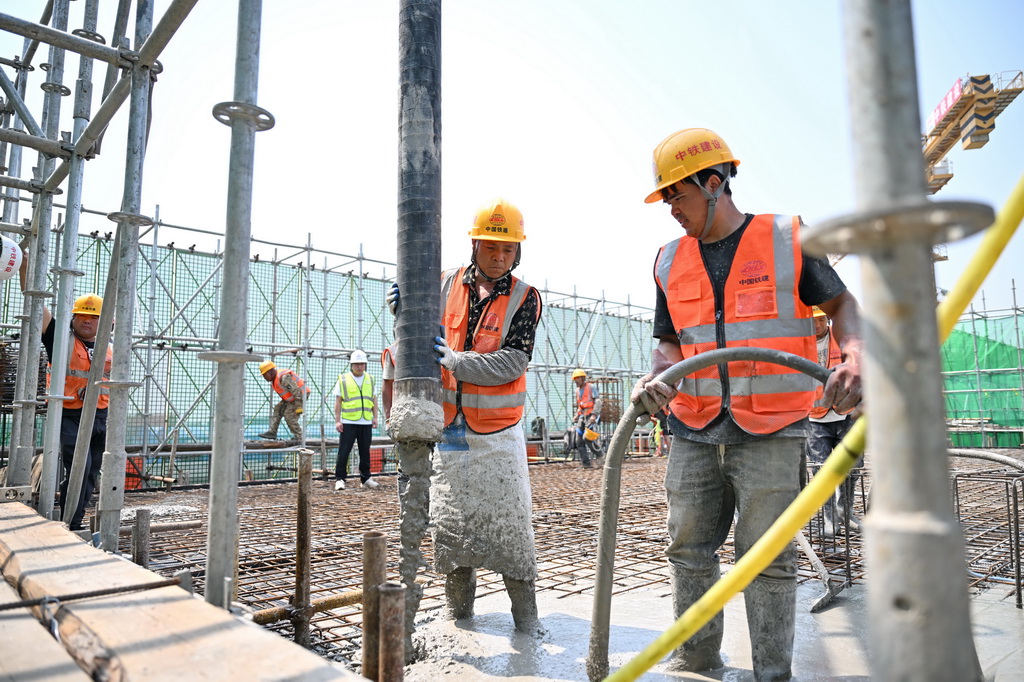 6月18日，中鐵建設集團工人在雄忻高鐵望都北站建設現場澆筑水泥。