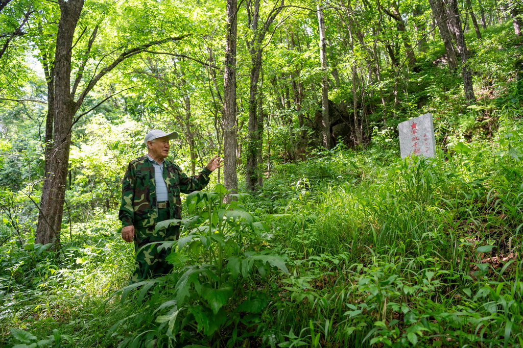 6月17日，在七星砬子抗聯密營遺址內，集賢縣革命老區建設促進會會長樸永鶴介紹抗聯十一軍軍政干部學校遺址。
