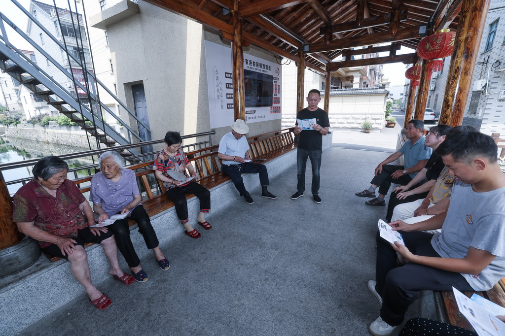 6月18日，長興縣李家巷鎮許家浜村的“和治理事會”的黨員志愿者（中）給村民普及夏季防溺水安全知識。