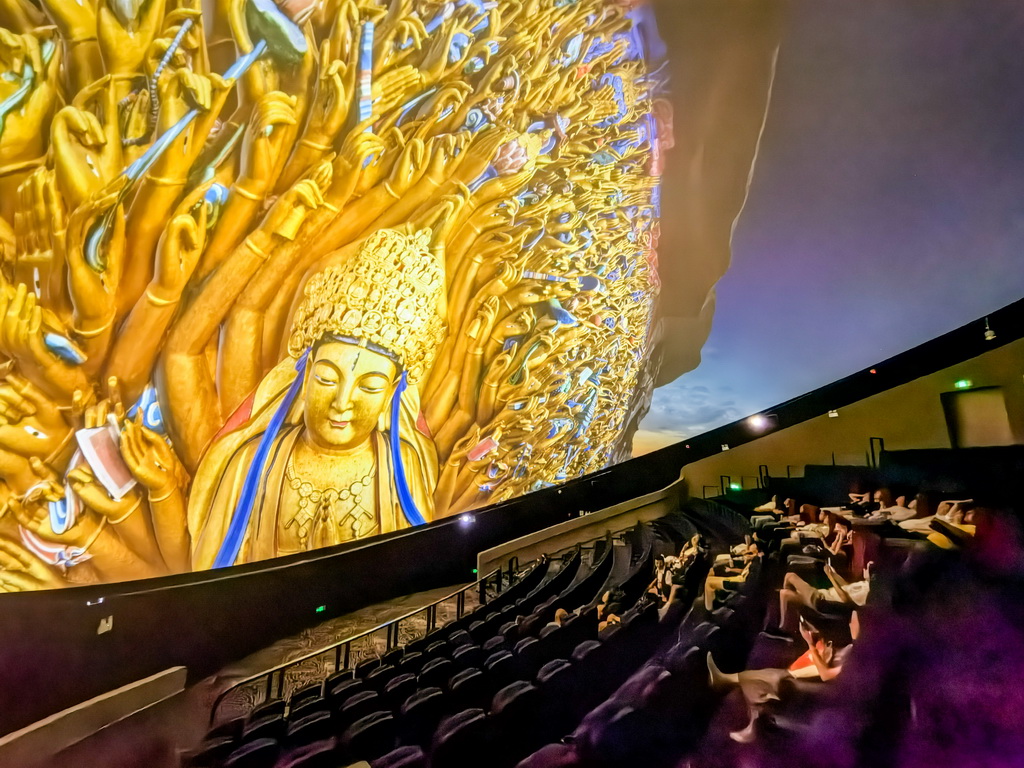 6月24日，游客在大足石刻景區觀看8K球幕電影。