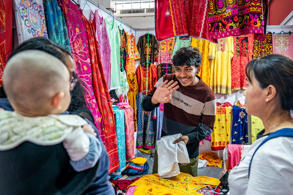 6月24日，在第9屆中國—南亞博覽會斯里蘭卡展區，展商和一名嬰兒打招呼。新華社記者 胡超 攝