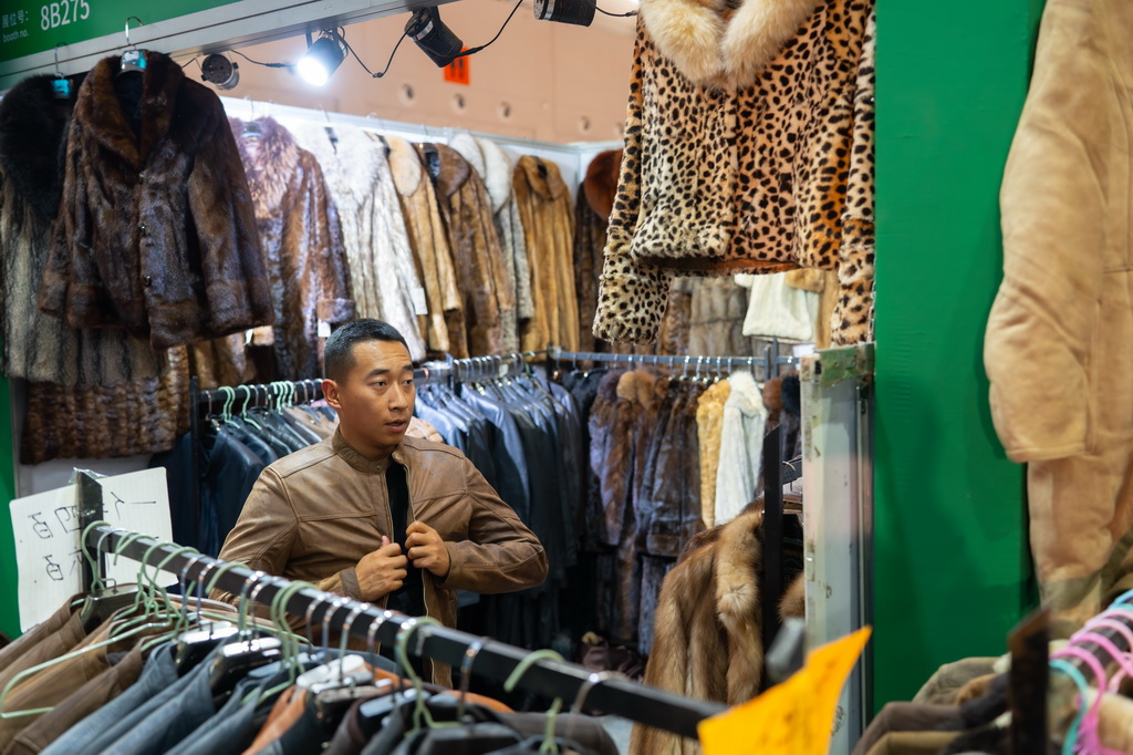 6月24日，游客在第9屆中國—南亞博覽會上試穿外套。新華社記者 高詠薇 攝