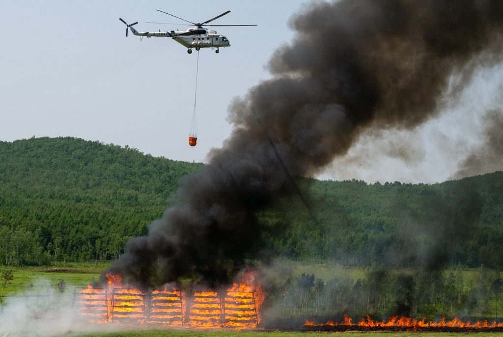 6月24日，在黑龍江省大興安嶺地區的演習現場，一架直升機實施吊桶灑水滅火。