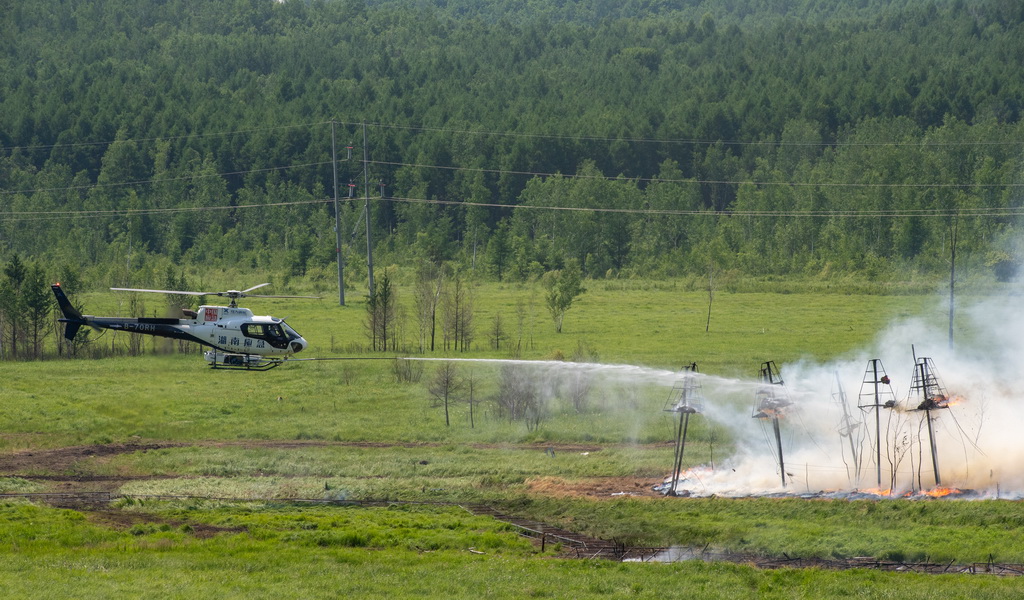 6月24日，在黑龍江省大興安嶺地區的演習現場，一架直升機用機載航空消防高壓水炮撲打樹冠火。