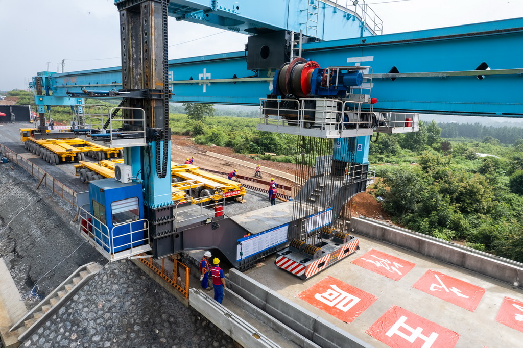 6月25日，在邵永高鐵柘刺坪特大橋建設工地，中鐵五局工人在進行架梁施工作業（無人機照片）。