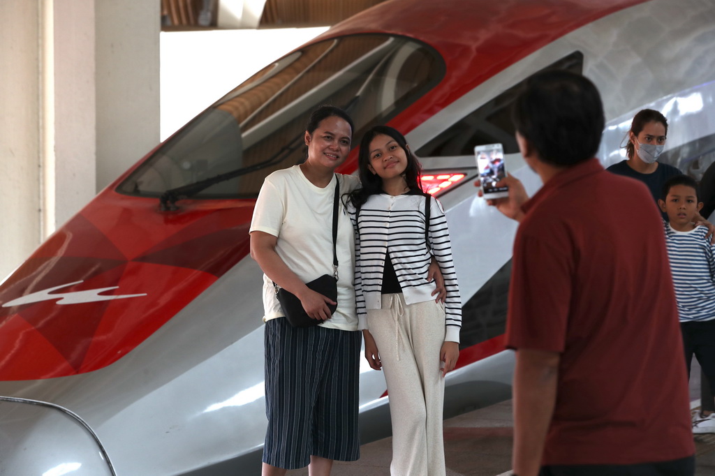 6月19日，在印度尼西亞雅加達哈利姆站站臺，兩名乘客與雅萬高鐵高速動車組列車合影。