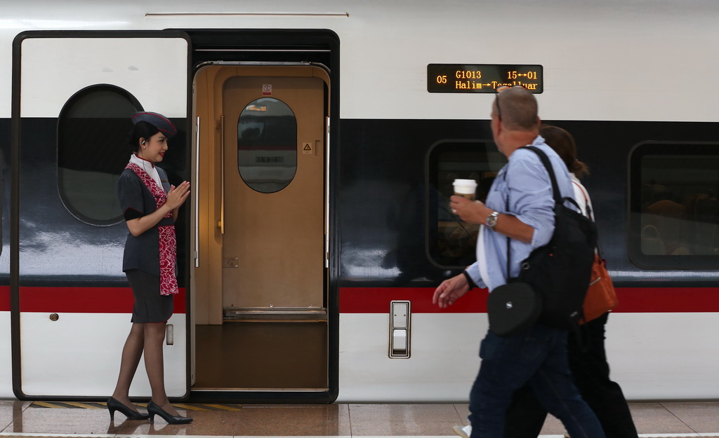 6月19日，一名乘務人員在印度尼西亞雅加達哈利姆站站臺歡迎乘客。