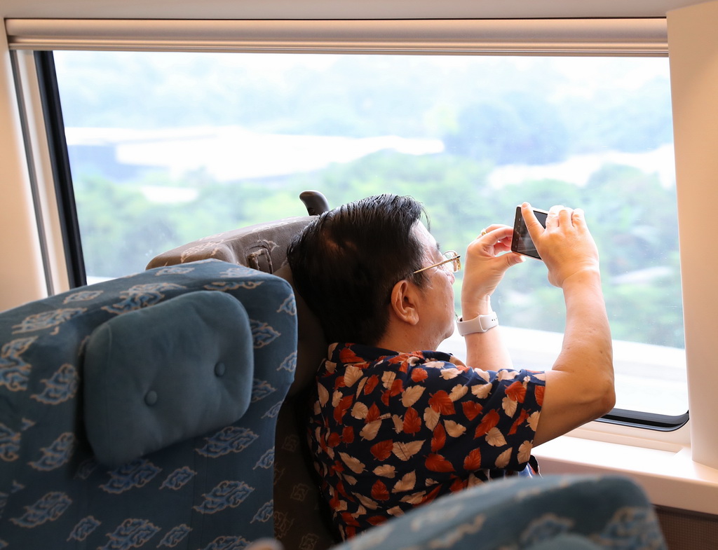 6月19日，一名乘客在行駛中的雅萬高鐵車廂內拍攝沿途風景。
