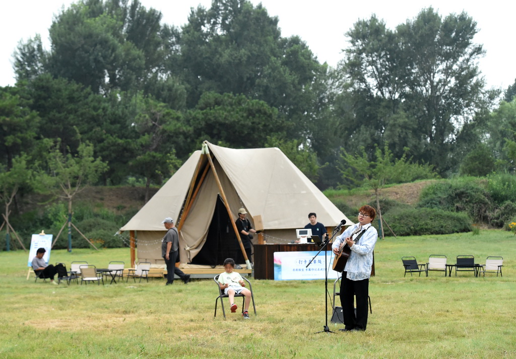 6月28日，一名歌手在圓明園“風荷朝露帳篷咖啡”處彈唱。