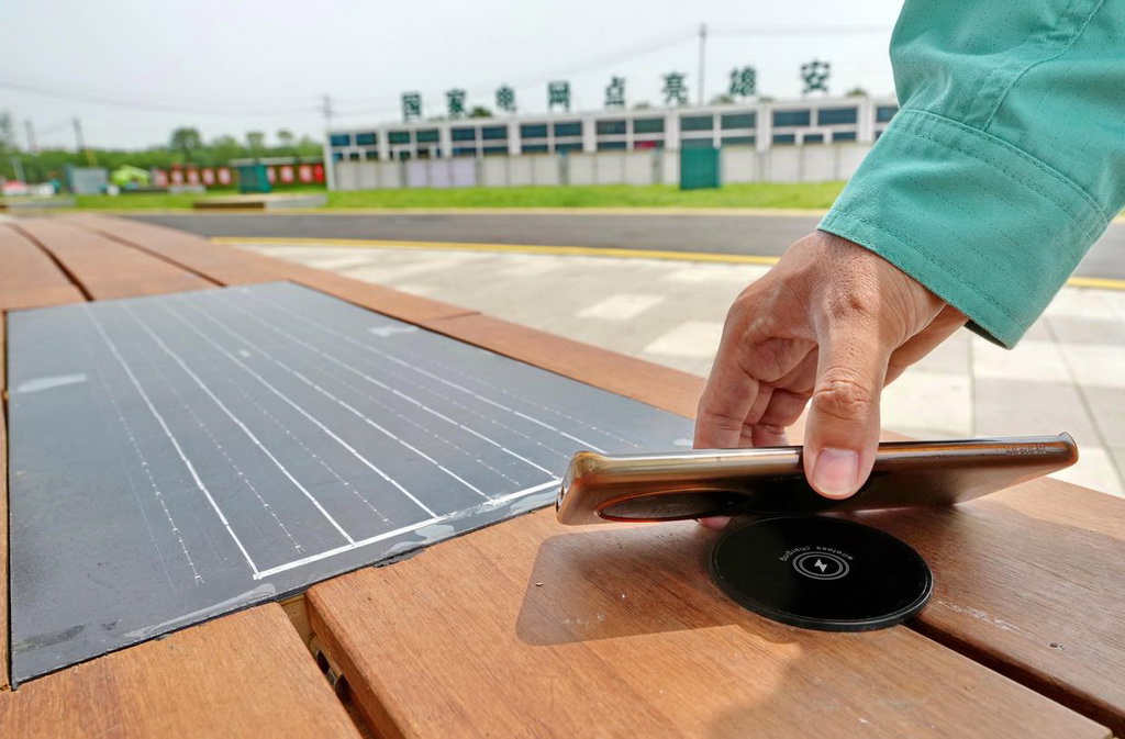 6月30日，工人在雄安新區復興220千伏變電站演示使用共享光伏手機充器給手機充電。