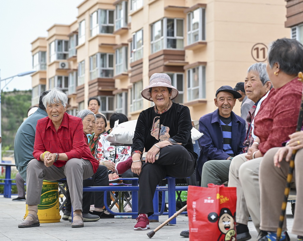 山西省忻州市靜樂縣小康苑移民安置區居民在小區廣場上休息乘涼（7月1日攝）。新華社記者 李鑫 攝