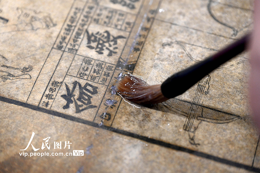 在河南省洛陽市圖書館古籍書庫，工作人員對破損古籍進行修復。