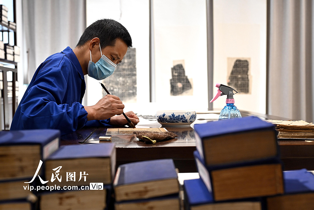 在河南省洛陽市圖書館古籍書庫，工作人員對破損古籍進行修復。