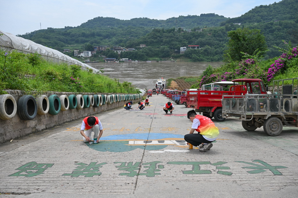  7月7日，志愿者在巴南區中壩島繪制創意圖案。