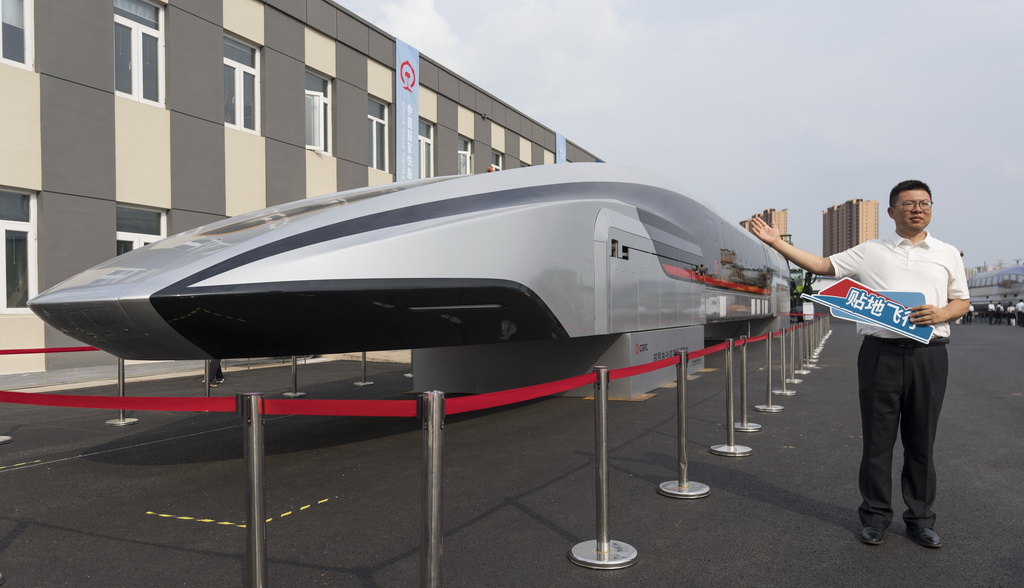 7月9日，在國家鐵道試驗中心展區，一名男子與國內首輛超導電動高速磁浮樣車合影留念。新華社記者 才揚 攝
