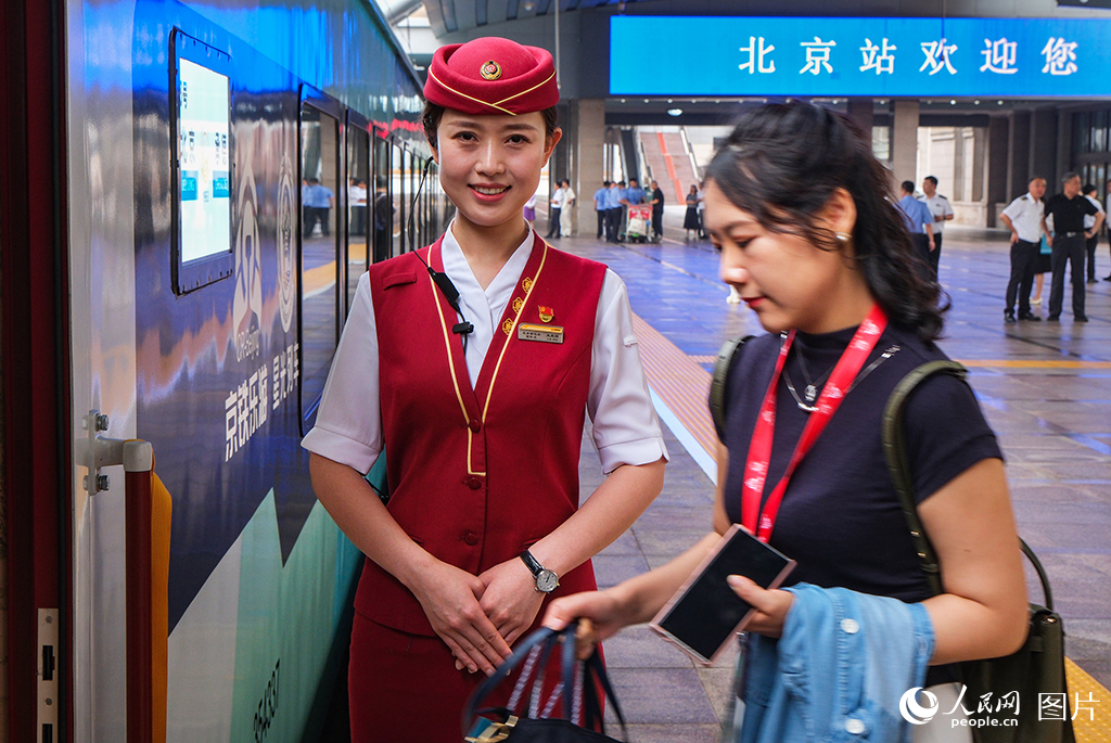 7月9日，乘務員迎接旅客乘車。