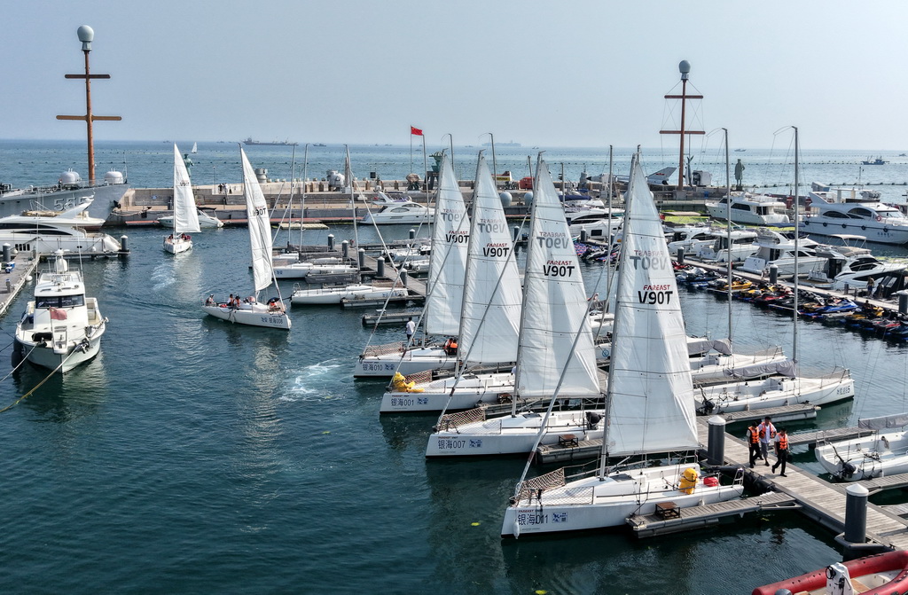 市民和游客在青島銀海大世界港池乘船參加海上巡游活動（7月10日攝，無人機照片）。