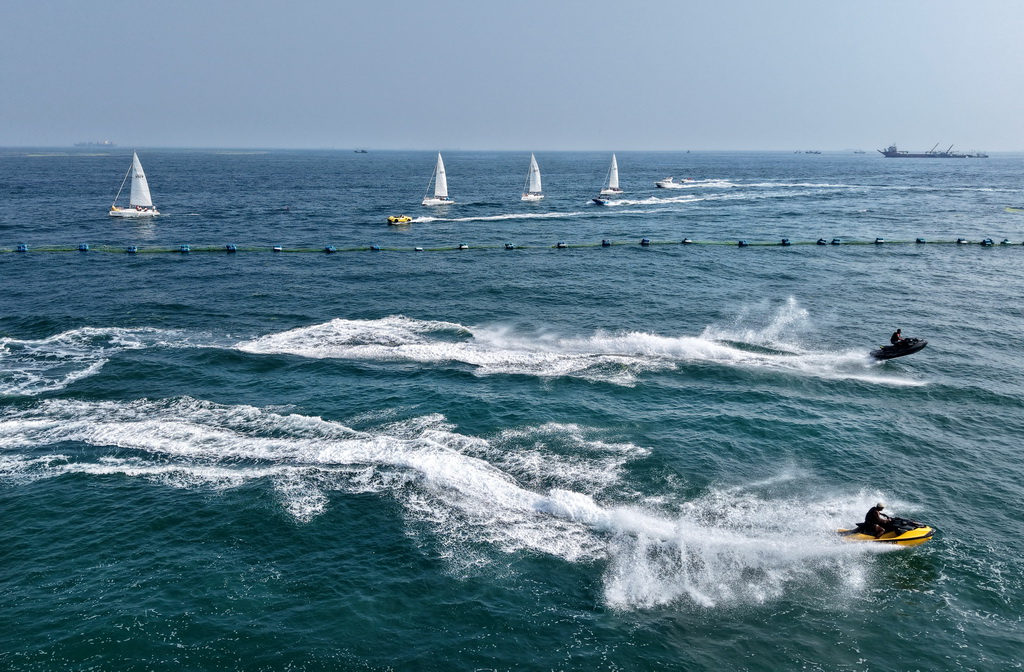 青島老龍灣海域，摩托艇參加海上巡游活動（7月10日攝，無人機照片）。