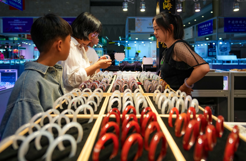 7月10日，消費者（左二）在昆明石博會上挑選玉石。