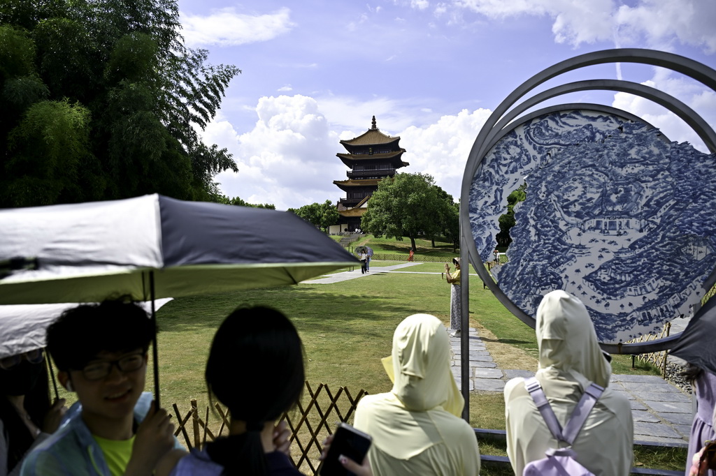 7月13日，游客在江西省景德鎮市陶陽里歷史文化街區一處網紅打卡點排隊留影。