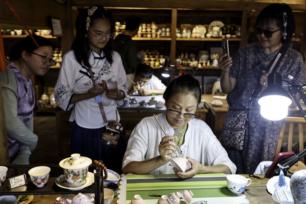 7月13日，游客在江西省景德鎮市陶陽里歷史文化街區觀摩現場創作。