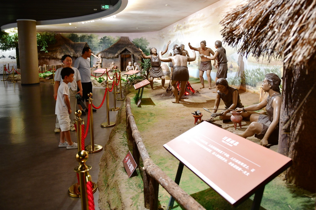 7月14日，游客在大汶口遺址博物館內參觀先民生活場景復原模型。