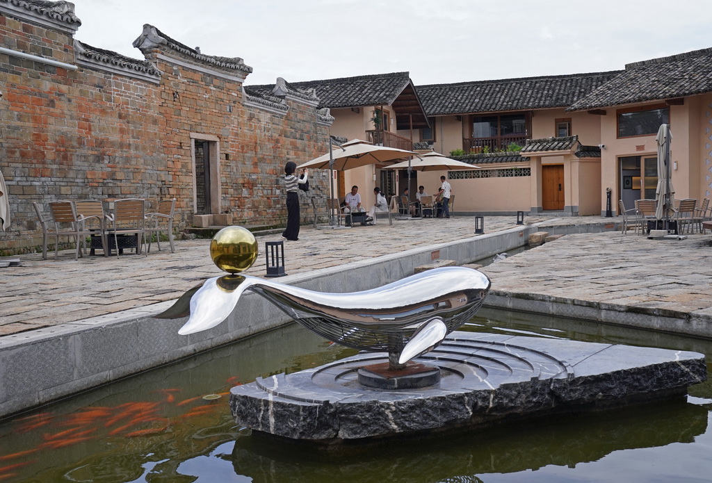 游客在龍南市關西鎮的田心圍民宿院子里休息（6月19日攝）。