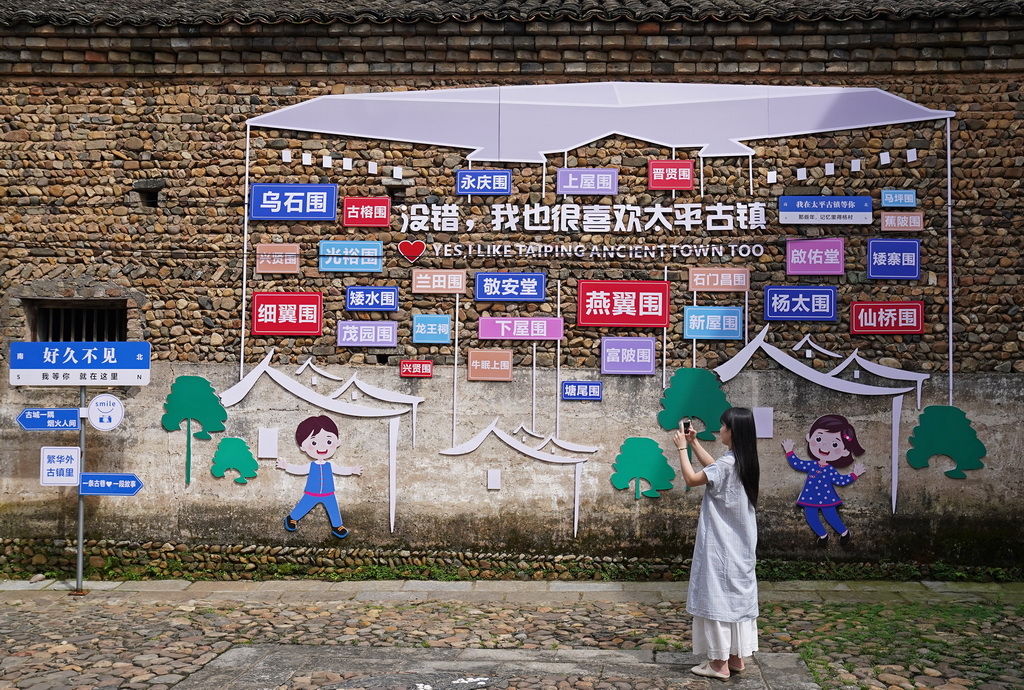 游客在龍南市楊村鎮燕翼圍周邊游覽（6月19日攝）。