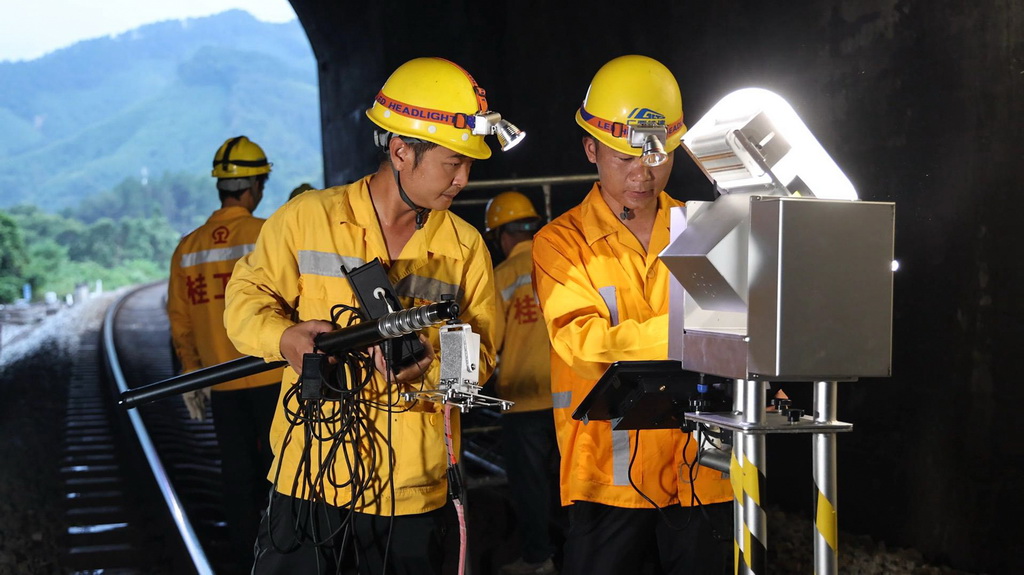 橋隧工人檢查隧道內鐵軌（7月16日攝）。