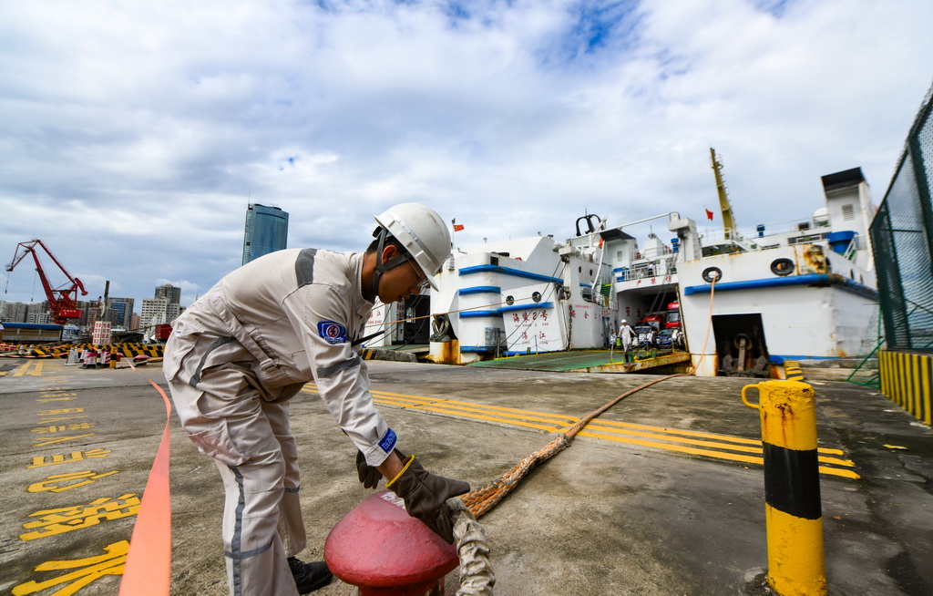 7月22日，在?？谑行阌⒏?，工作人員為剛靠泊的客滾船固定纜繩。