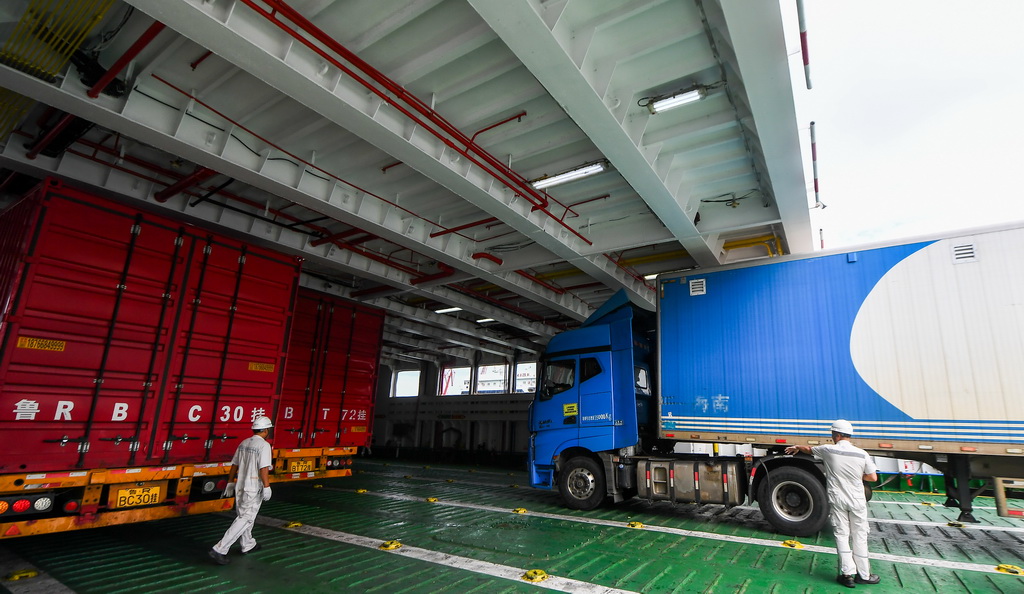 7月22日，在?？谑行阌⒏?，貨車在工作人員指揮下駛入客滾船。