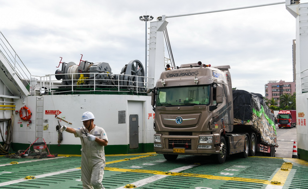 7月22日，在?？谑行阌⒏?，貨車在工作人員指揮下駛入客滾船。