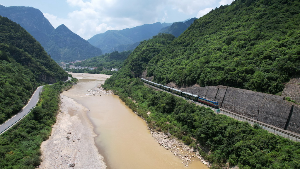 7月15日，一列火車行駛在嘉陵江畔的寶成鐵路上（無人機照片）。新華社記者 陳斌 攝