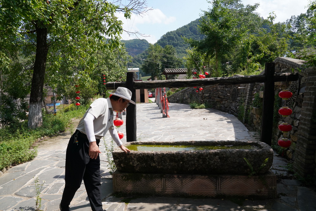7月14日，在甘肅省隴南市徽縣大河店鎮青泥村，徽縣博物館文博副研究館員曹鵬雁在介紹一件古代石馬槽。新華社記者 馬寧 攝