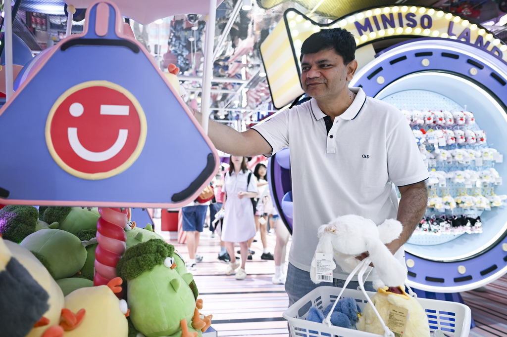 7月17日，一名印度游客在位于上海市南京路步行街的一家潮玩店里挑選商品。新華社記者 唐斯琦 攝