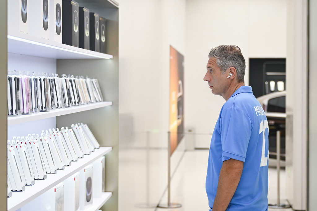 7月17日，一名外國游客在位于上海市南京路步行街的華為商店里瀏覽電子產品。新華社記者 陳浩明 攝