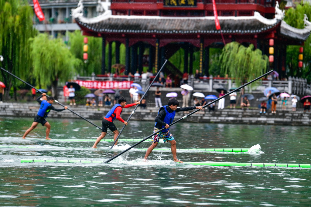 7月23日，參賽隊員在貴州省鎮遠縣?陽河上進行獨竹漂比賽。