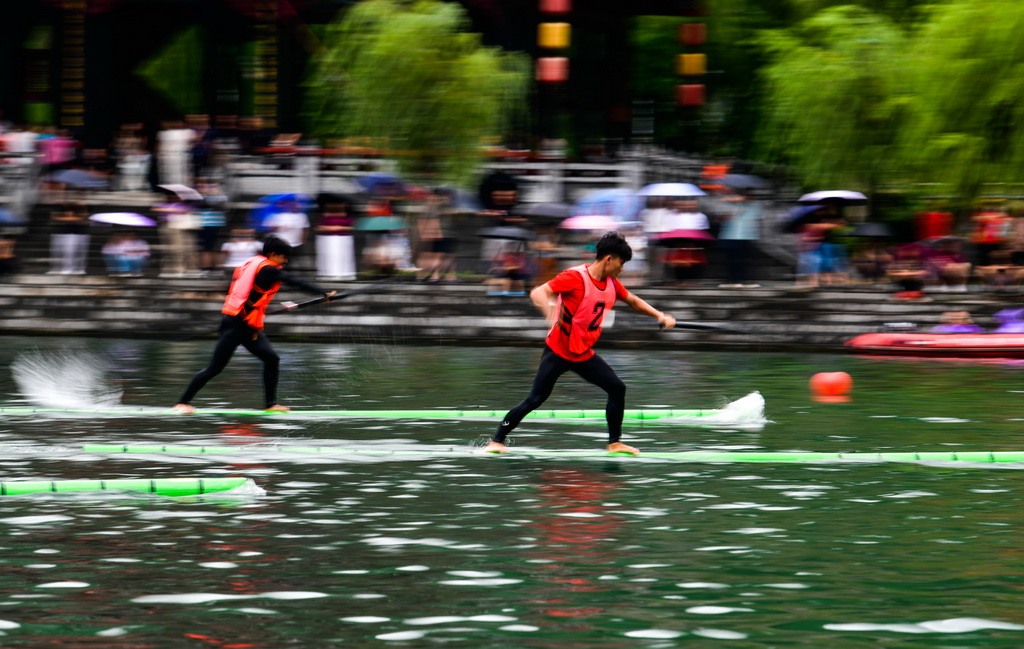 7月23日，參賽隊員在貴州省鎮遠縣?陽河上進行獨竹漂比賽。