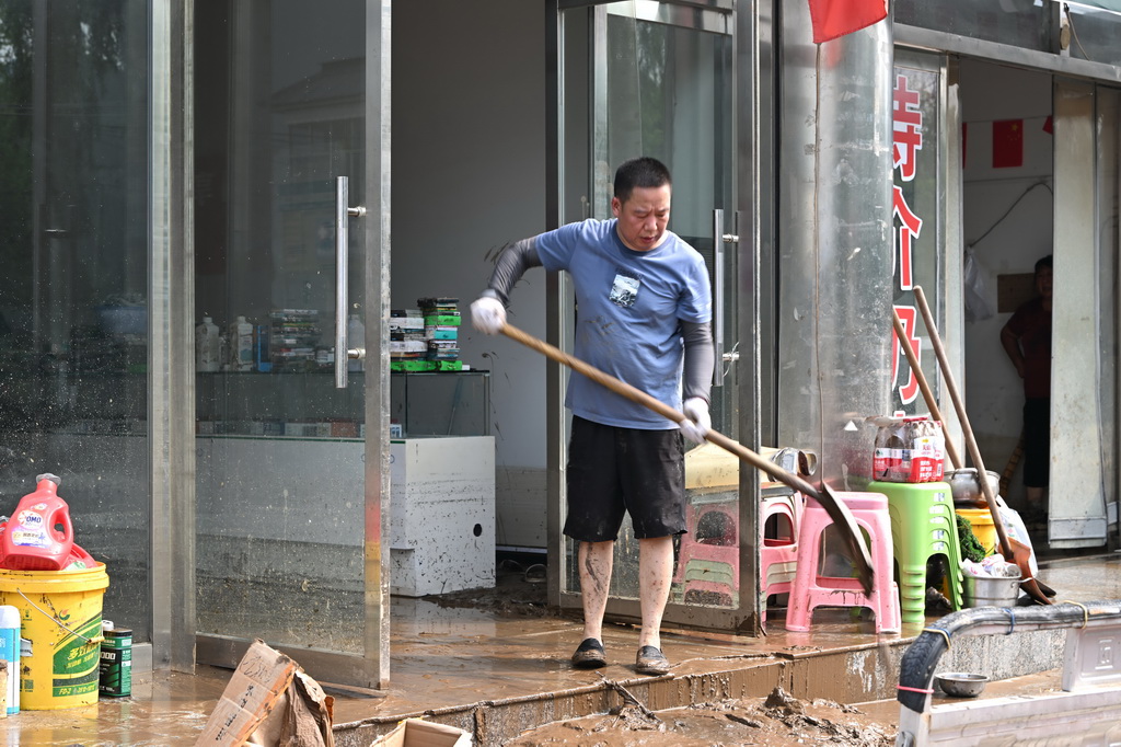 7月28日，居民在天津市薊州區下營鎮下營村清理屋內的淤泥。