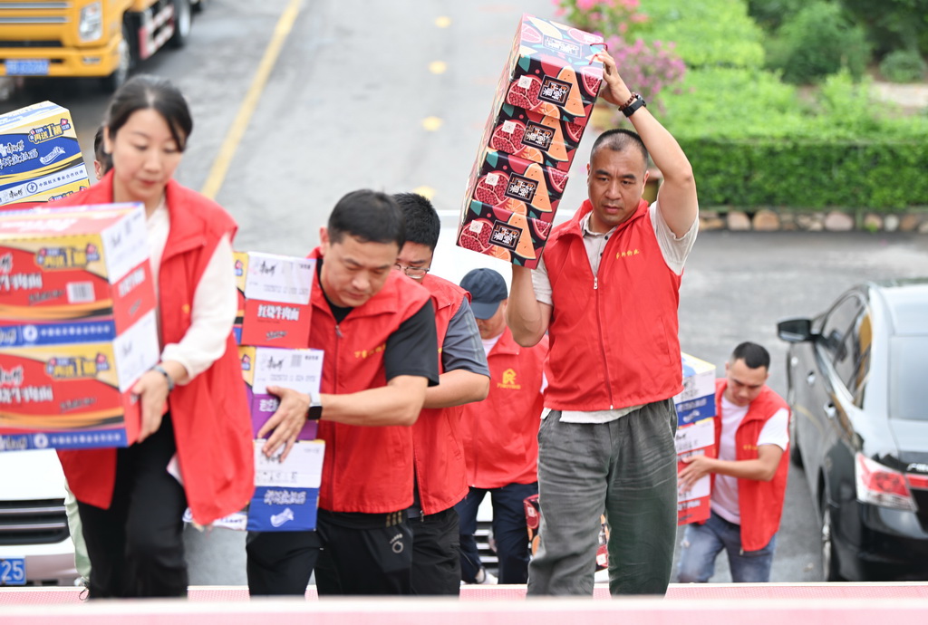 7月28日，志愿者在天津市薊州區下營鎮初級中學安置點搬運物資。