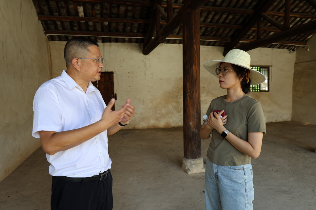 大悟縣革命傳統教育基地管理委員會副主任付波（左）在新四軍第五師國際招待所內向記者講述歷史（7月21日攝）。新華社記者 朱唯希 攝
