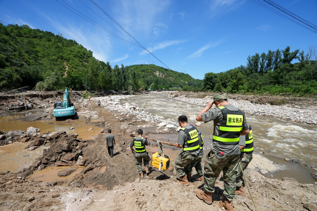 7月30日，在密云區馮家峪鎮，救援人員向道路被阻斷的村莊運送物資。