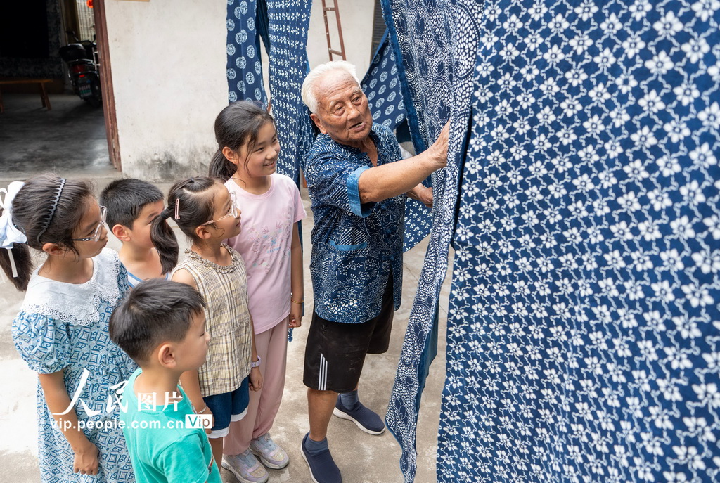 8月4日，國家級非遺南通藍印花布印染技藝代表性傳承人王振興老人向小朋友介紹藍印花布的制作技藝。