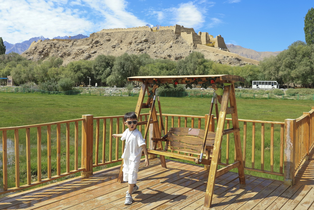 8月2日，一名小游客在新疆塔什庫爾干塔吉克自治縣阿拉爾國家濕地公園游玩。