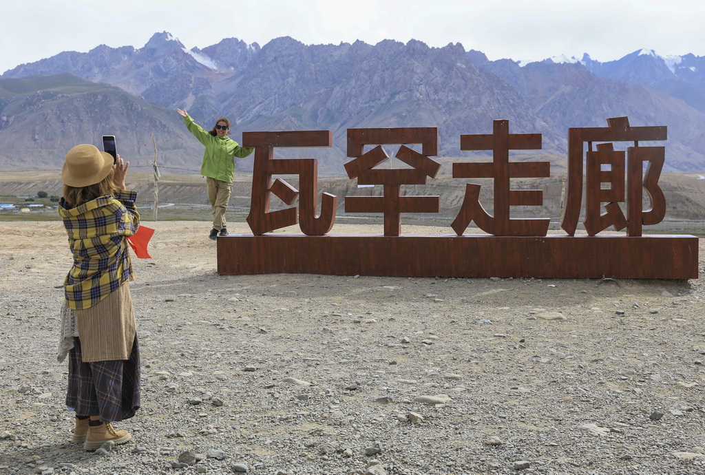 8月2日，游客在位于新疆塔什庫爾干塔吉克自治縣的瓦罕走廊入口處拍照留念。