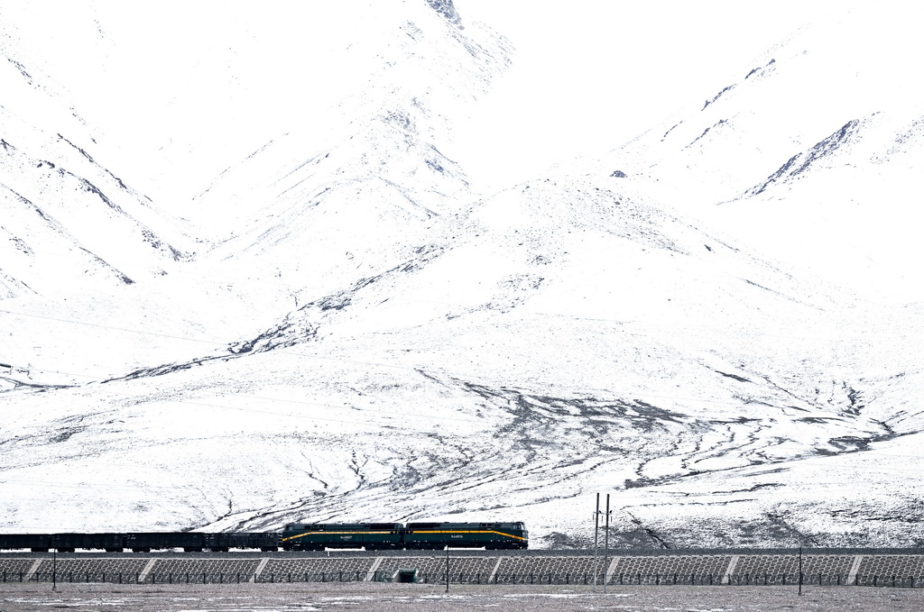 2024年5月27日，列車行駛在昆侖山下的青藏鐵路上。新華社記者 張龍 攝