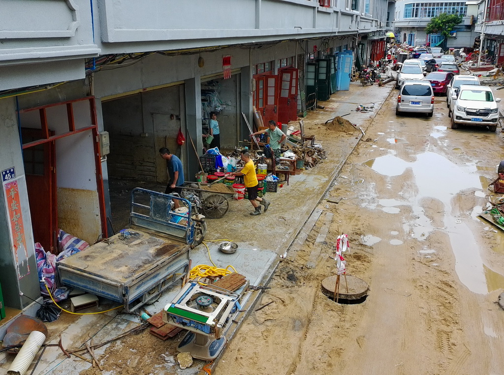 8月6日，村民在廣東清遠佛岡縣石角鎮黃花村清理屋內淤泥與雜物（無人機照片）。