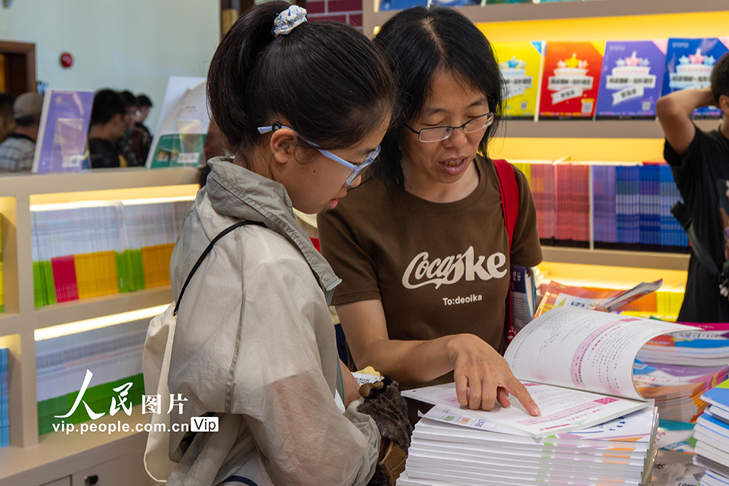 2025年8月13日，2025上海書展當天開幕，眾多讀者在上海展覽中心書展主會場內挑選、閱讀、購買圖書。王岡攝（人民圖片網）