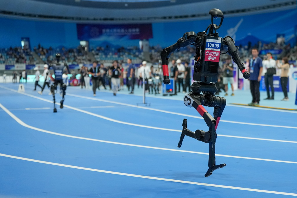 8月17日，在世界人形機器人運動會4x100米接力決賽中，來自靈翌科技隊的人形機器人（前）在比賽中。